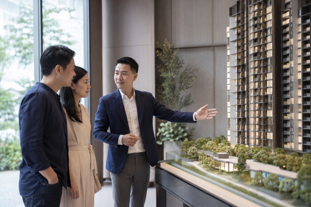 Property consultant showing a scale model of a new development to a couple